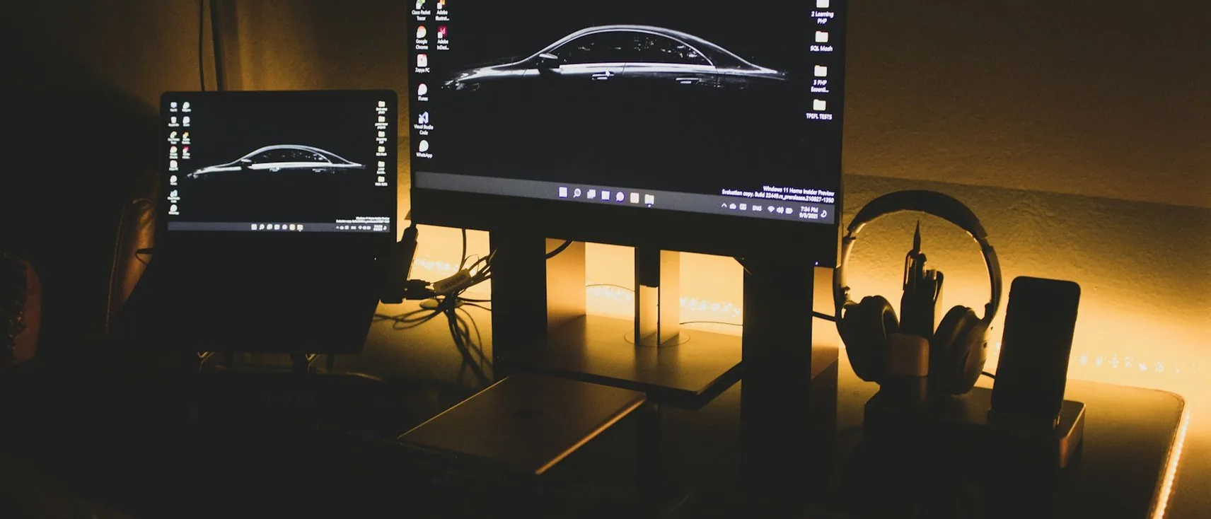 a laptop showing a car on screen — header, wide